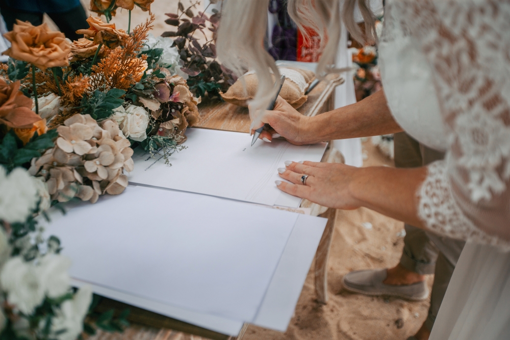 Braut unterschreibt Dokument am Hochzeitstag