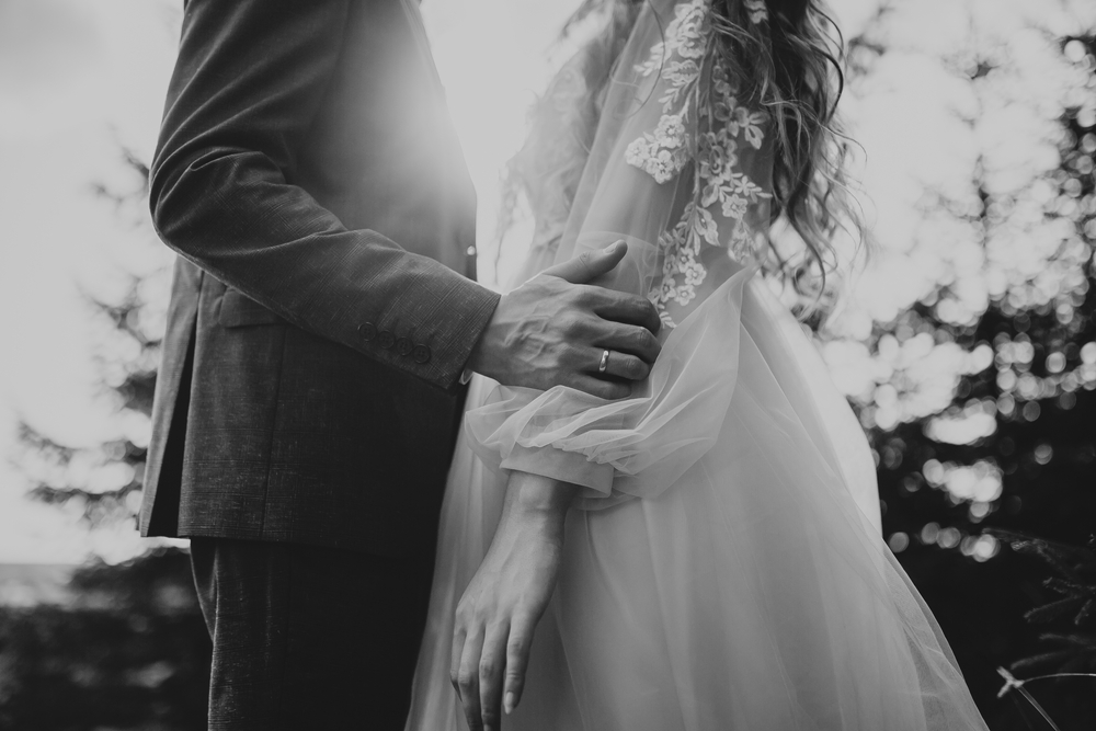 Detailaufnahme Brautpaar umarmend am Hochzeitstag in Schwarz-Weiß